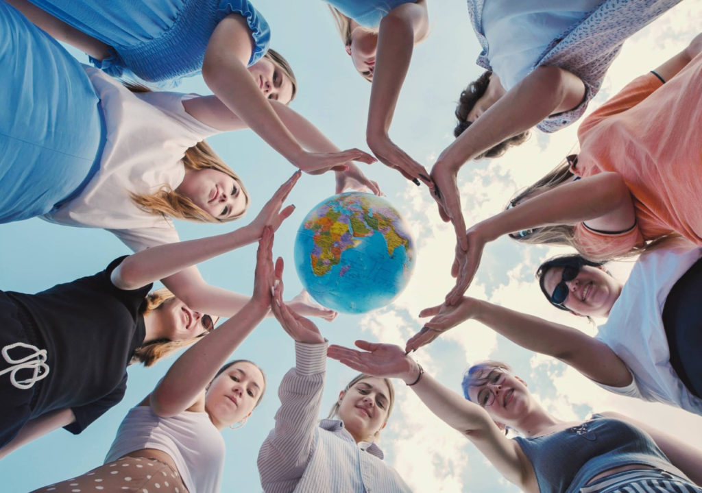 People reaching towards a globe